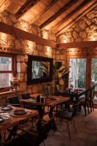Warm and inviting rustic restaurant interior with stone walls and wooden beams.